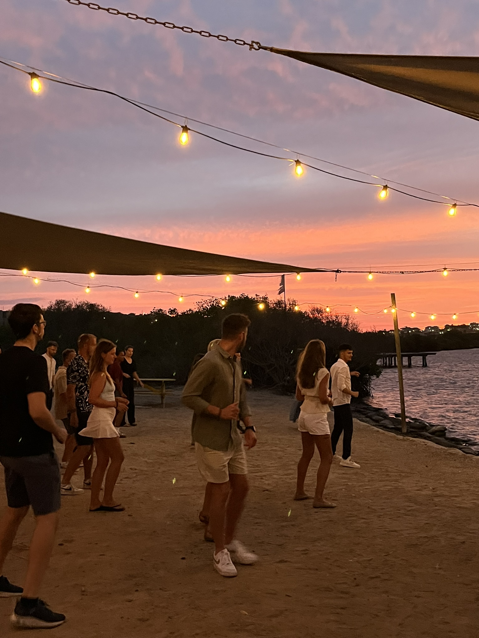 Guests enjoying an outdoor Latin dance experience by the water in Curaçao